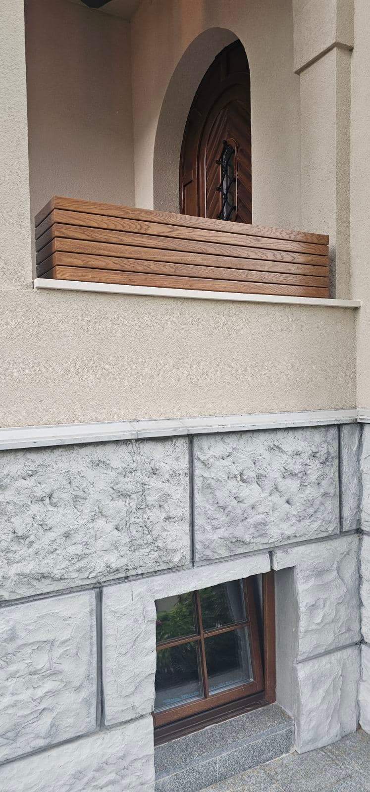 Drvena prozorska žardinjera na kamenoj fasadi kuće