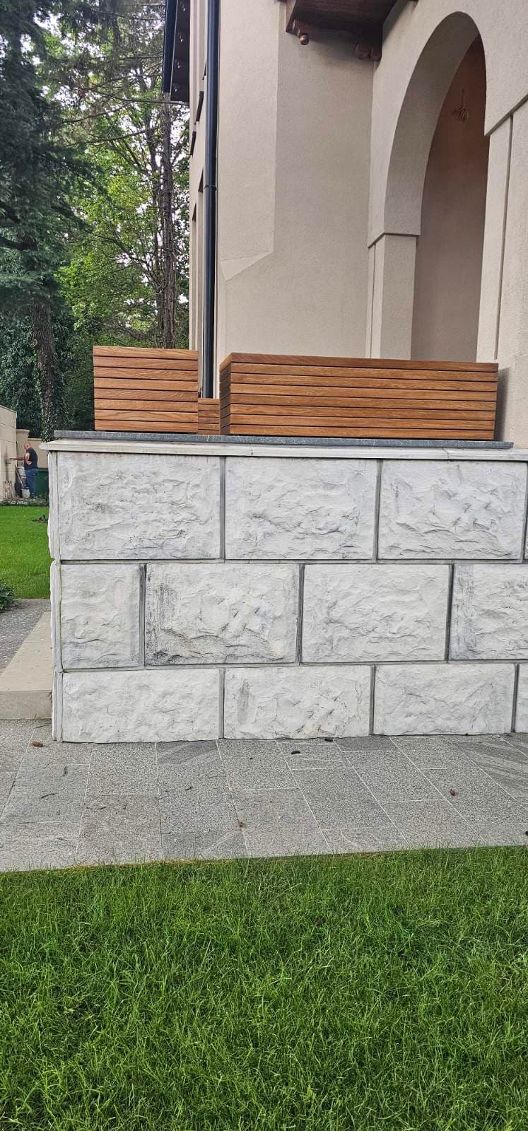 Drvene žardinjere sa letvicama postavljene na ogradni zid kuće