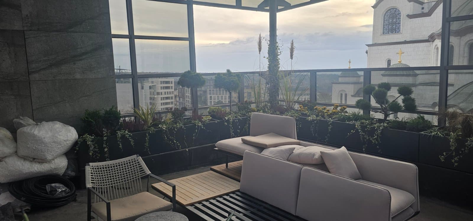 Crne metalne žardinjere u lounge enterijeru sa pogledom na Hram Svetog Save