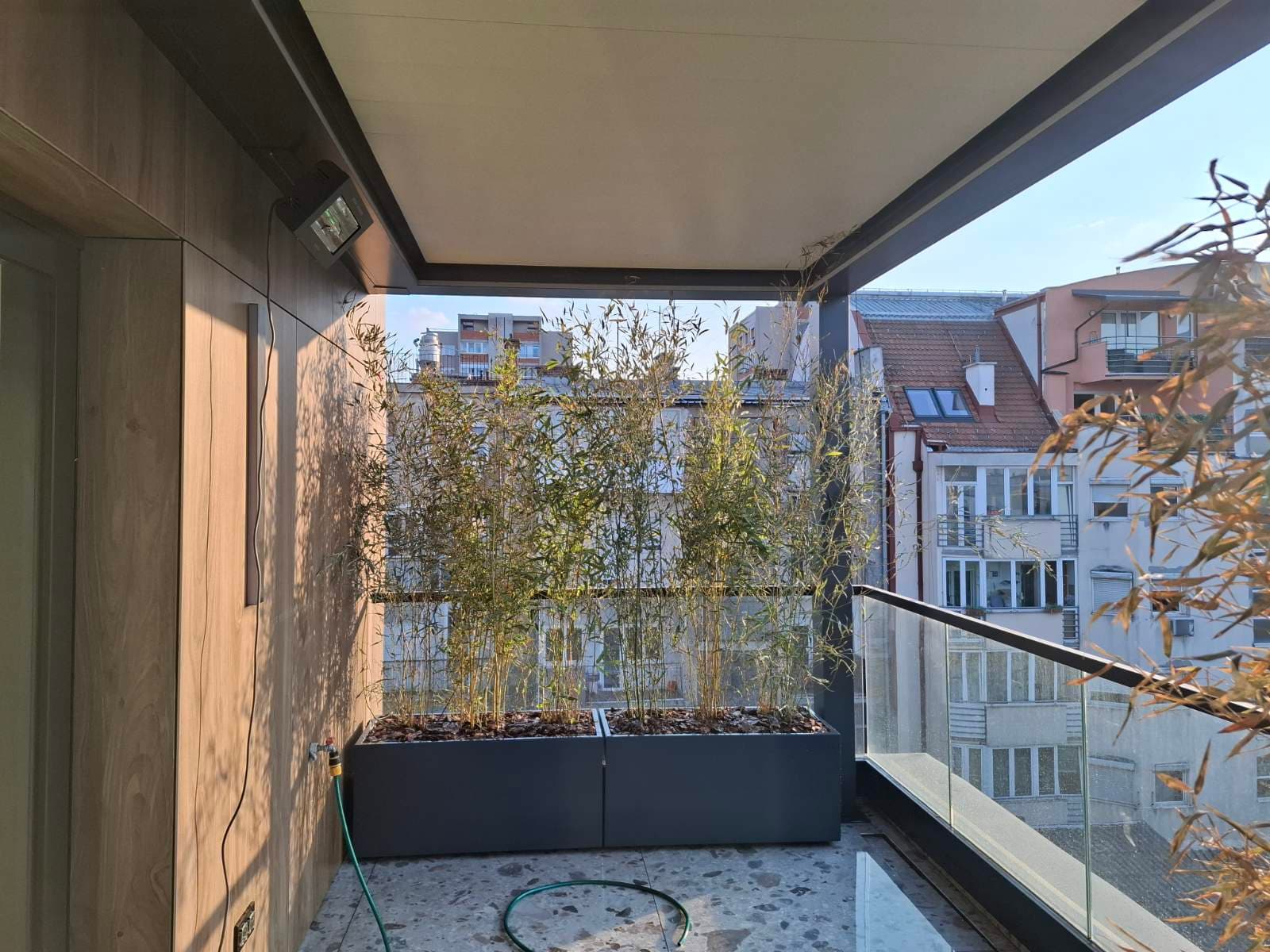 Antracit metalna žardinjera sa bambusom na natkrivenoj terasi stana